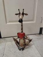 Zittende giraf met hart van gerecycled blik