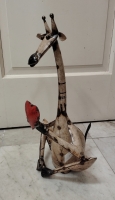 Zittende giraf met hart van gerecycled blik